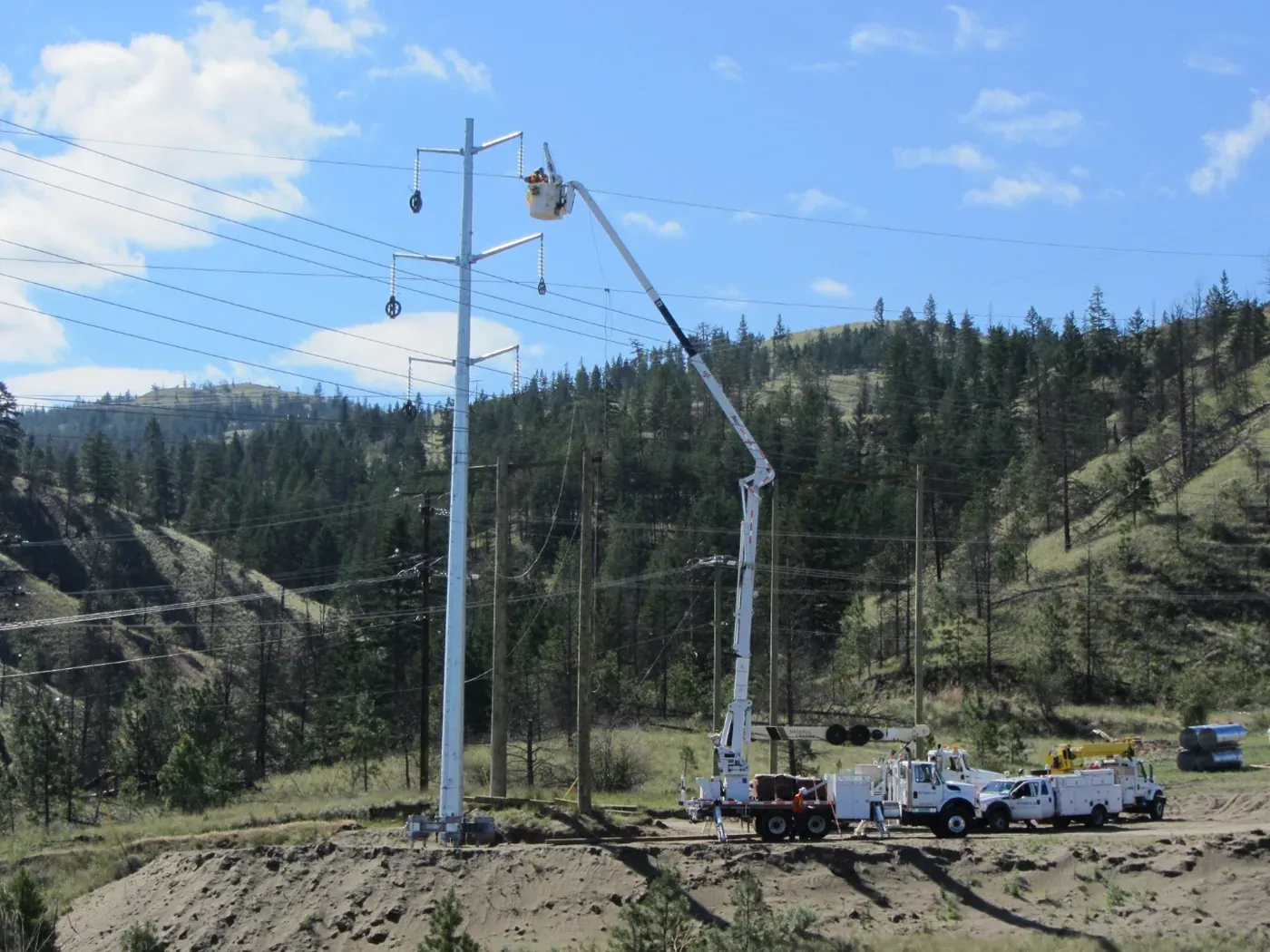 Distribution monopole and bucket truck in a mountain valley