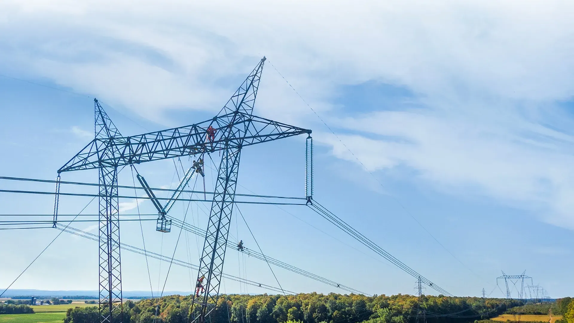 High-voltage transmission line at dusk over open terrain